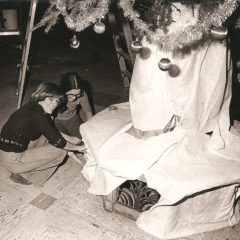 (FNB.2010.2.01) - Two Women Installing a Christmas Tree Skirt, First National Center, c. 1974