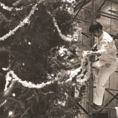 (FNB.2010.2.02) - Two Men Hang Garland on Christmas Tree in the Great Banking Hall, First National Center, c. 1974