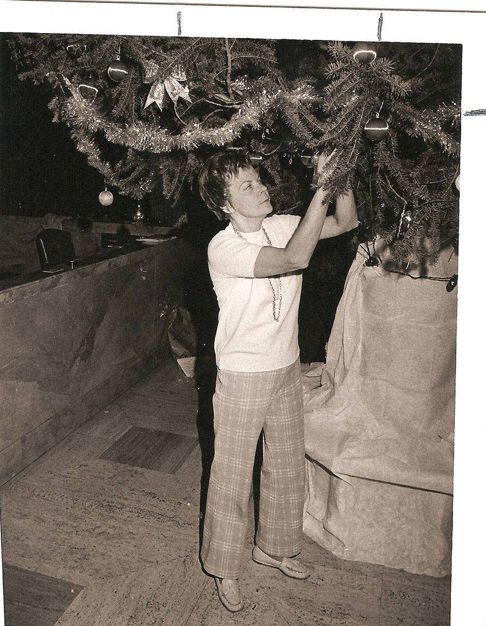 (FNB.2010.2.03) - Woman Decorating Christmas Tree in the Great Banking Hall, First National Center, c. 1974