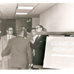 (FNB.2010.12.19) - Men Gathered Near Post Office in First National Center, c. 1970